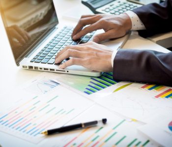 Working process startup. Businessman working at the wood table with new finance project. Modern notebook on table. Pen holding hand